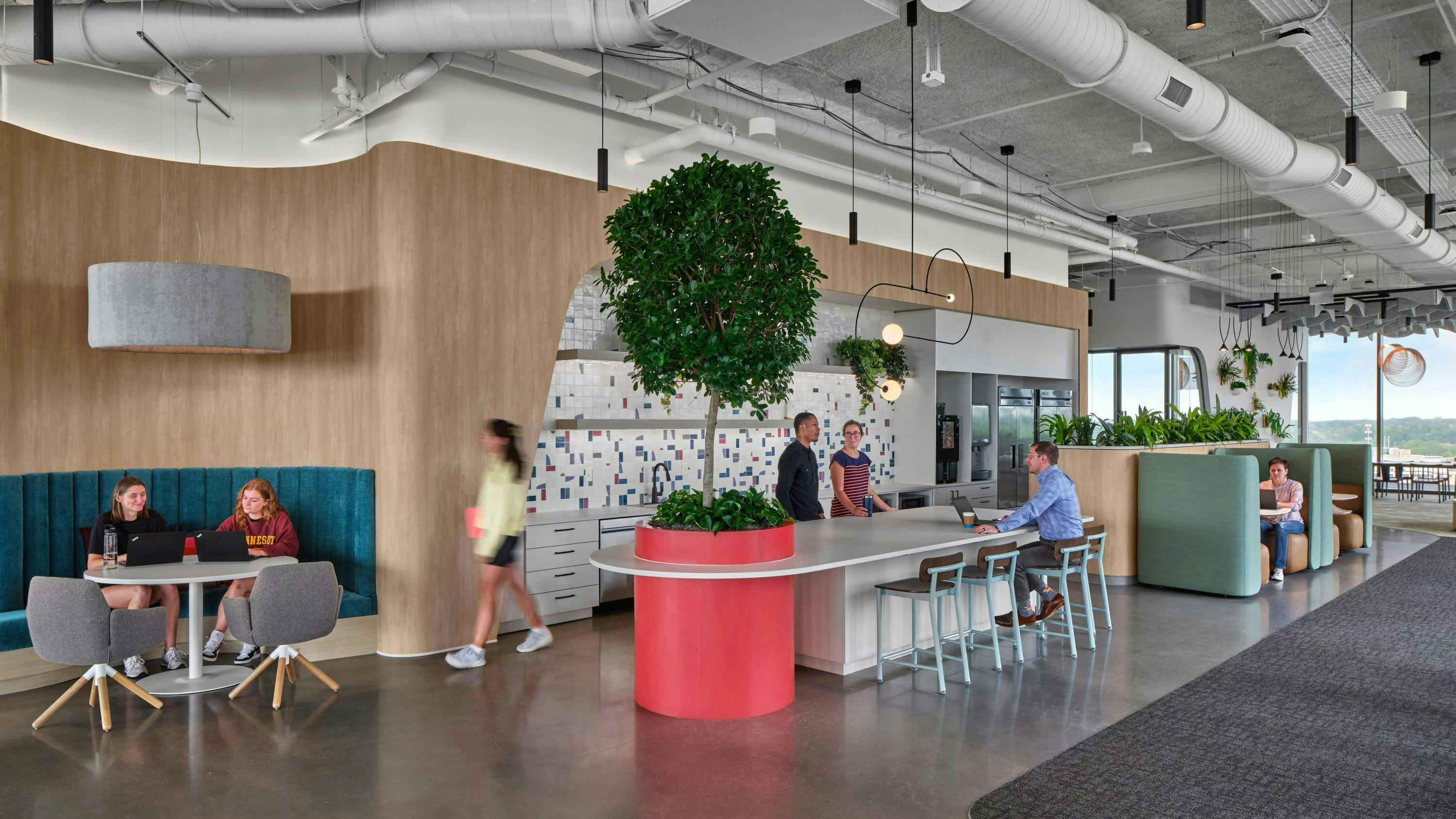 Northeastern University employee dining area shows exposed ceiling infrastructure, gray toned flooring, and natural wood-look accents