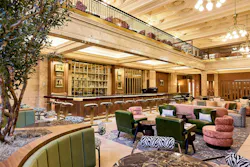 The restored Banking Hall features marble floors, stone columns, a barista bar, layered lighting, and vintage-inspired furnishings that create a welcoming, hotel-like arrival. The restored Banking Hall features marble floors, stone columns, a barista bar, layered lighting, and vintage-inspired furnishings that create a welcoming, hotel-like arrival.