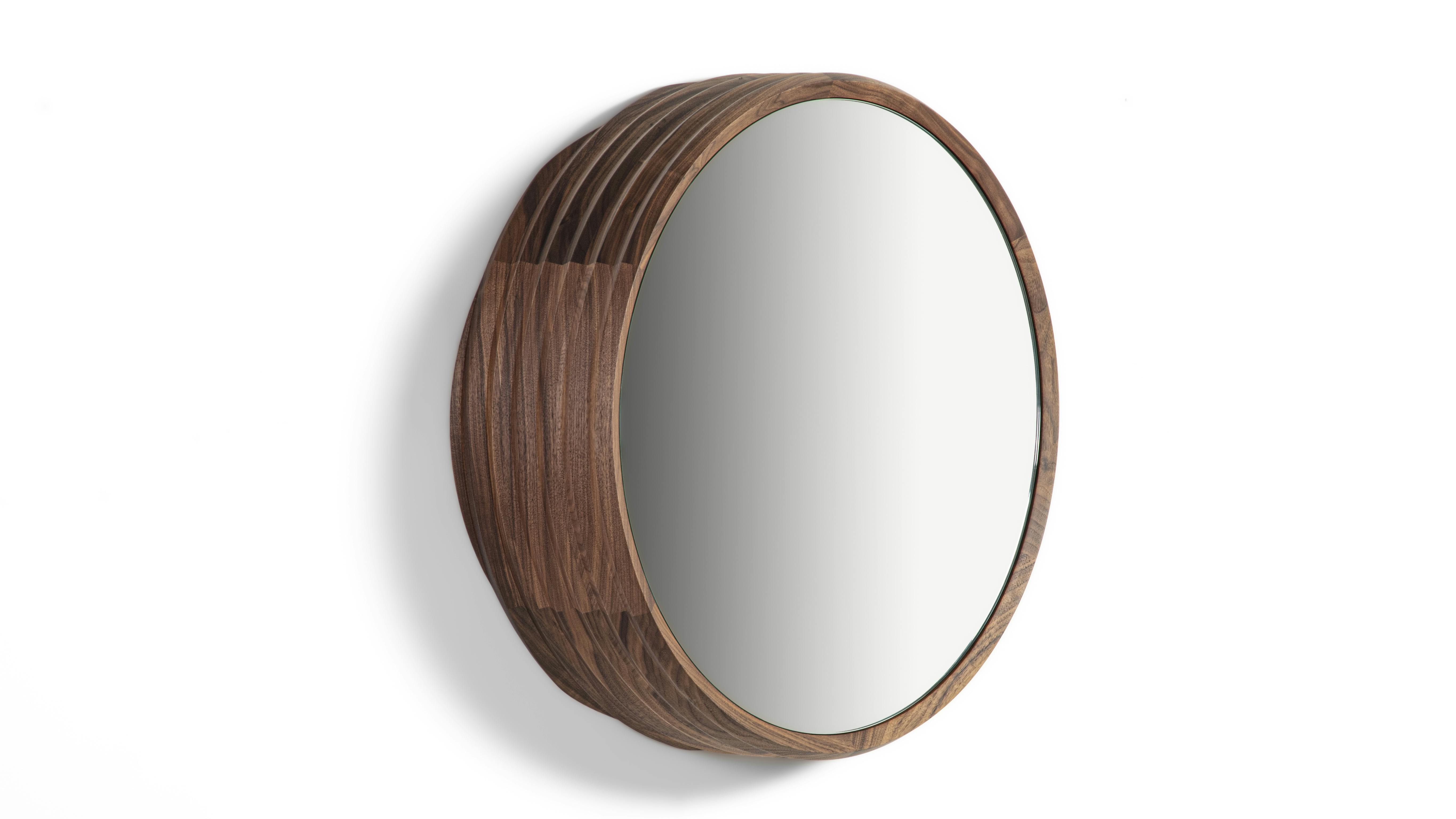 Slice Mirrors feature an asymmetrical solid Canaletta walnut frame.