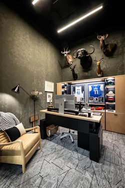 A Dude Perfect private office blends curated furnishings, linear lighting, and industrial-inspired carpet patterns to balance the sports memorabilia and other rustic decor. A Dude Perfect private office blends curated furnishings, linear lighting, and industrial-inspired carpet patterns to balance the sports memorabilia and other rustic decor.