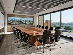 Conference room with wide windows, ergonomic seating, a large display, and acoustic ceiling system Conference room with wide windows, ergonomic seating, a large display, and acoustic ceiling system