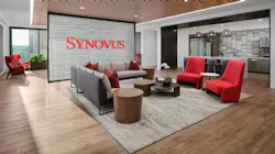 Open cafe and lounge area with Synovus red branding and accents grounded by neutral wood and stone look surfaces Open cafe and lounge area with Synovus red branding and accents grounded by neutral wood and stone look surfaces