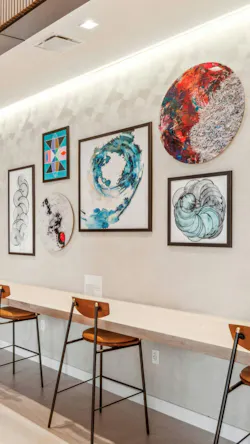 Gallery wall featuring paintings, sketches, and 3D artwork in complementary hues of turquoise, deep rust, black, ivory, and grap Gallery wall featuring paintings, sketches, and 3D artwork in complementary hues of turquoise, deep rust, black, ivory, and grap