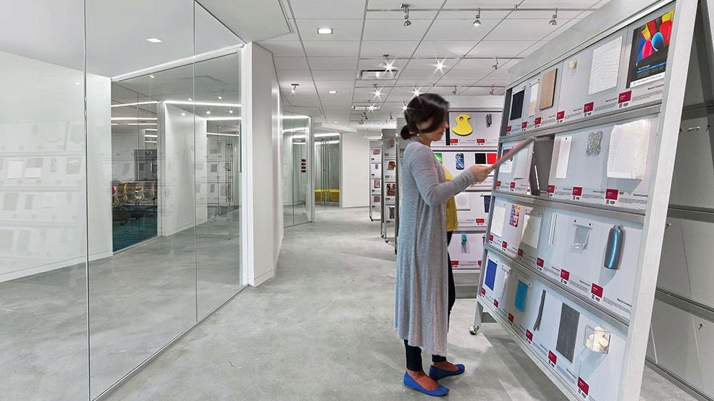 Woman standing in front of material samples shelving in ASID materials library.