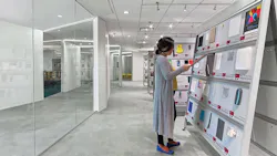 Woman standing in front of material samples shelving in ASID materials library. Woman standing in front of material samples shelving in ASID materials library.