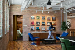 Listening lounge with turntable, albums displayed on the brick wall, and blue retro lounge chairs near the Chladni plate device that offers visual and hands-on engagement for occupants Listening lounge with turntable, albums displayed on the brick wall, and blue retro lounge chairs near the Chladni plate device that offers visual and hands-on engagement for occupants