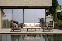 Bronze metal-framed lounge chairs and sofa on patio Bronze metal-framed lounge chairs and sofa on patio