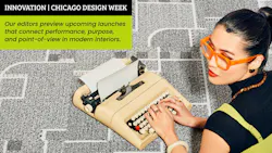 Woman wearing orange framed glasses lays on her stomach on patterned carpeting, while working on a vintage typewriter Woman wearing orange framed glasses lays on her stomach on patterned carpeting, while working on a vintage typewriter