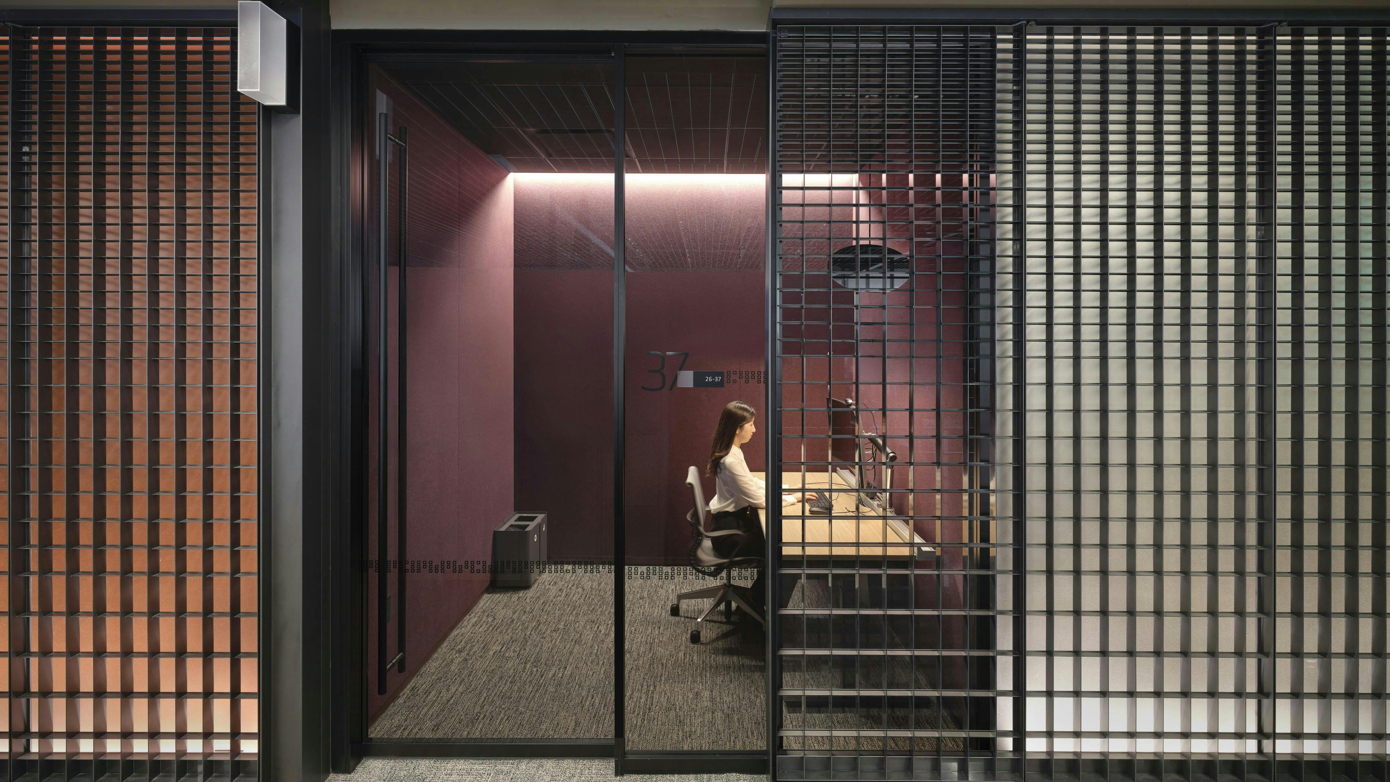 Worker in glass-walled office that shows the continuity of Dreamwall displays in the corridor