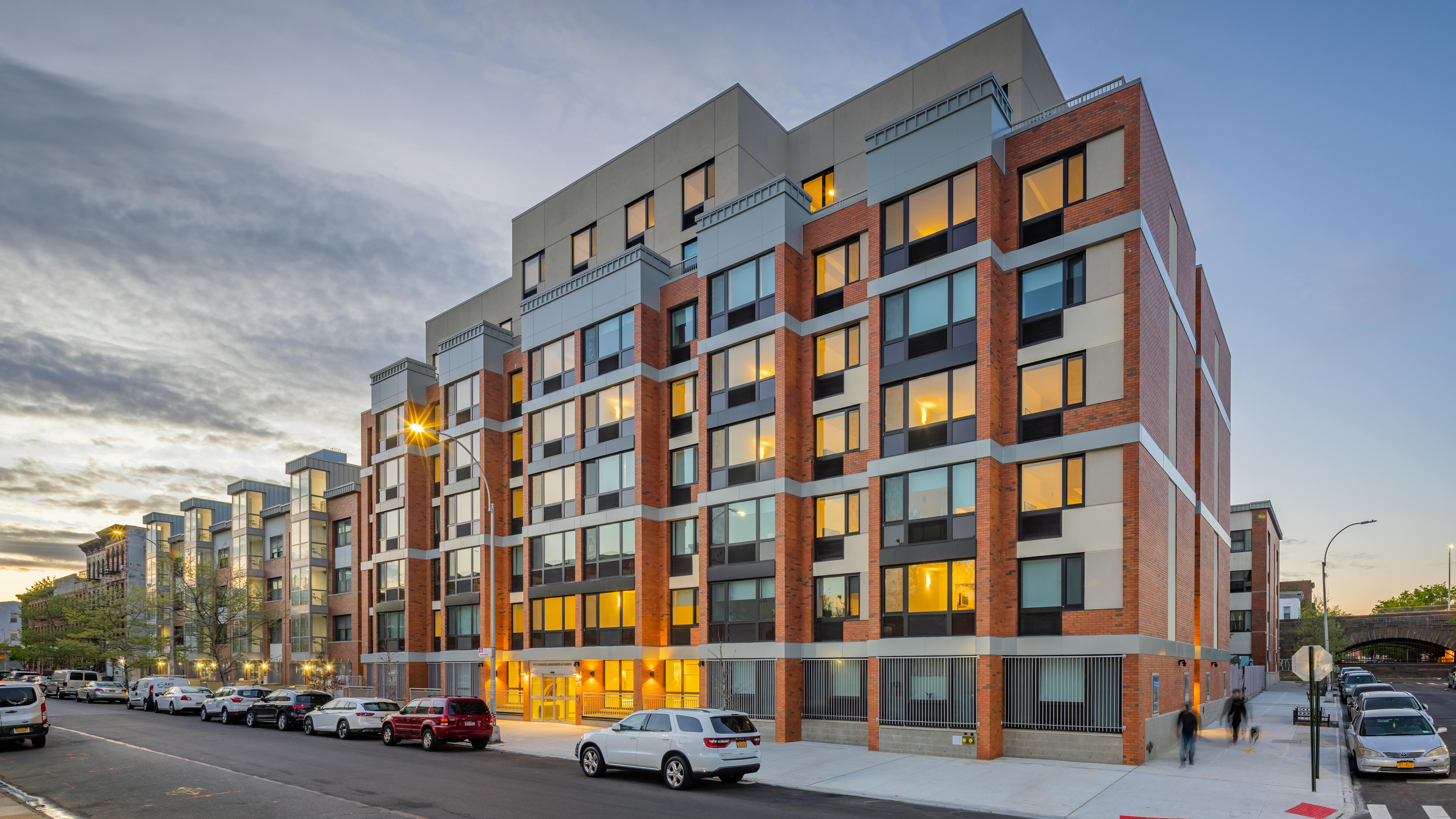 Exterior view of new affordable multifamily project at dusk.