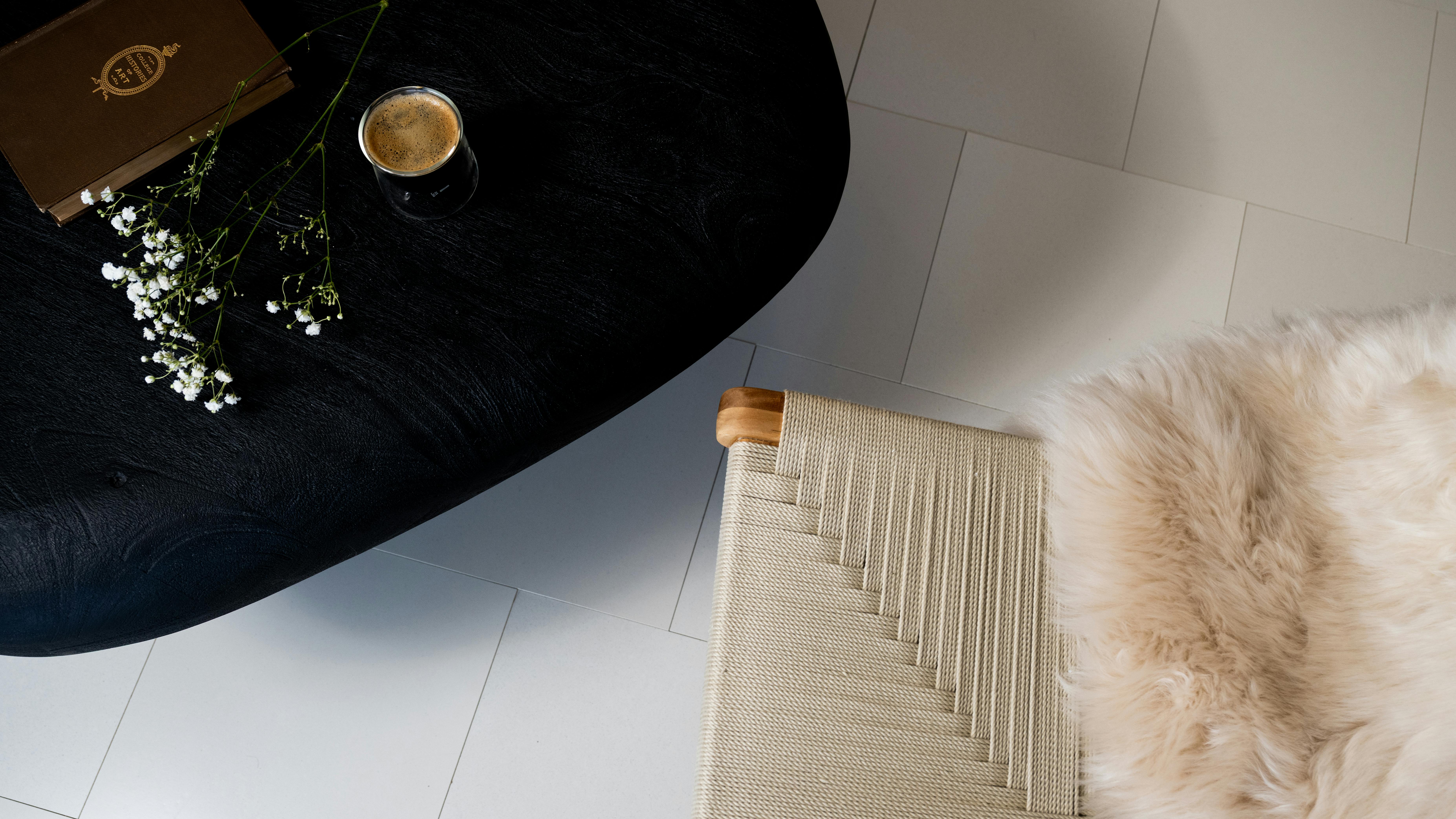 Bio-based flooring material in white with dark velvet chair and fluffy cushions
