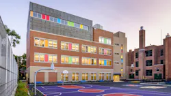 Exterior of colorful K-12 building in background with basketball court in foreground. Exterior of colorful K-12 building in background with basketball court in foreground.