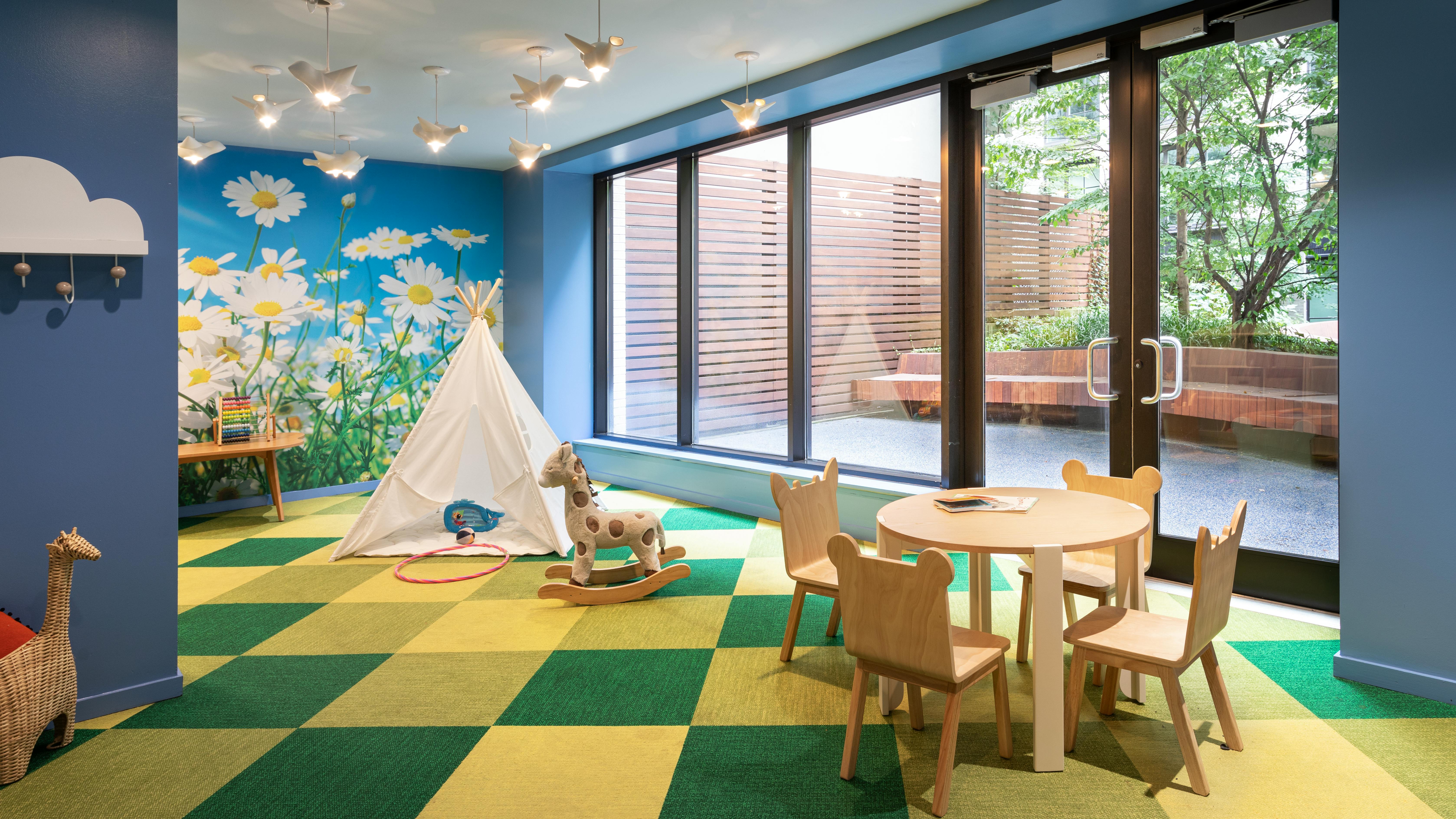 Multi-family residential building offers a childrens' playroom with controlled access to outdoor patio