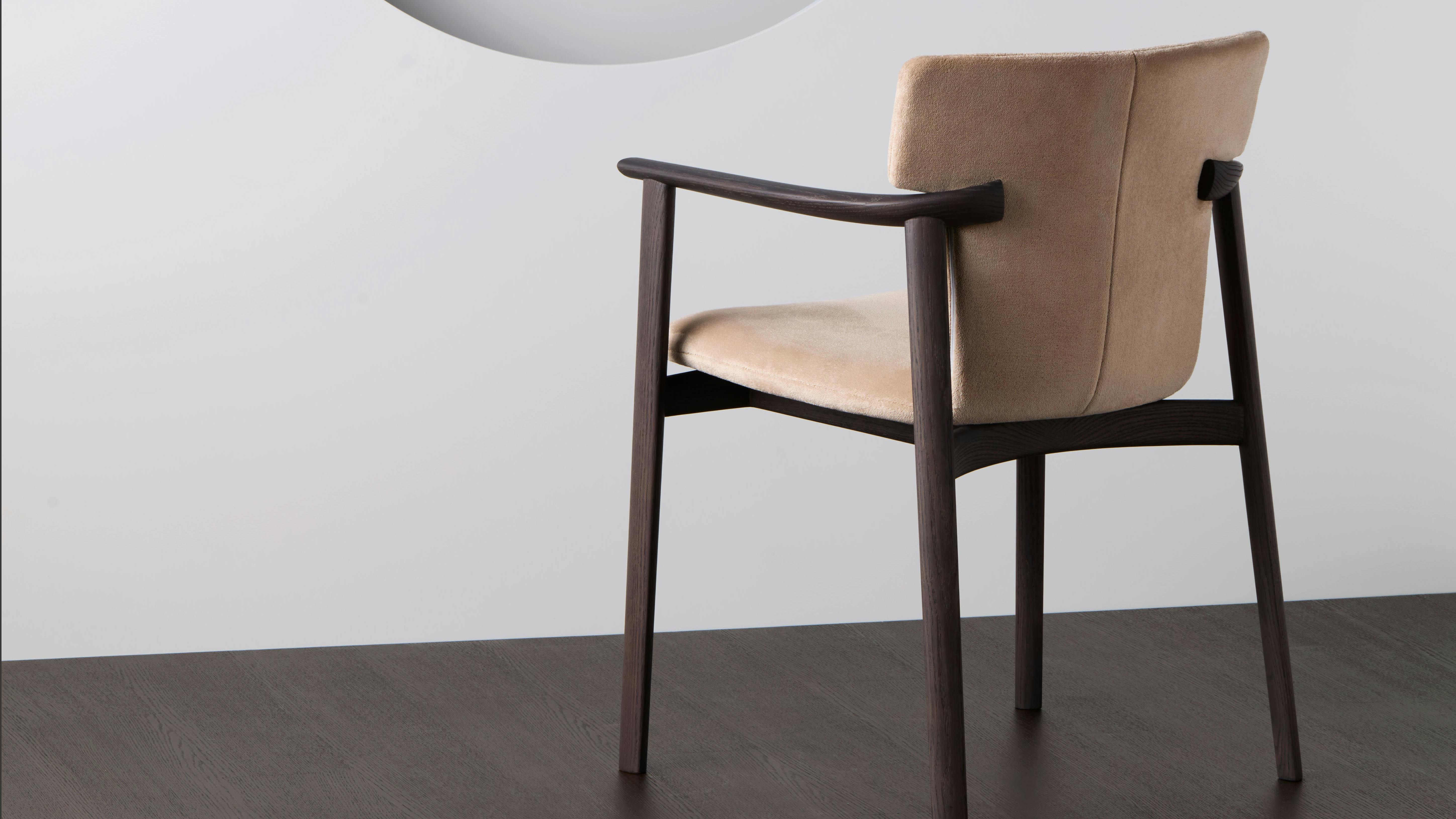The Timothy Dining Armchair features a distinctive T-shaped joint where the back leg meets the arm.