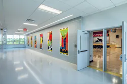 Interior school wall with colorful, geometric panels showing student activities