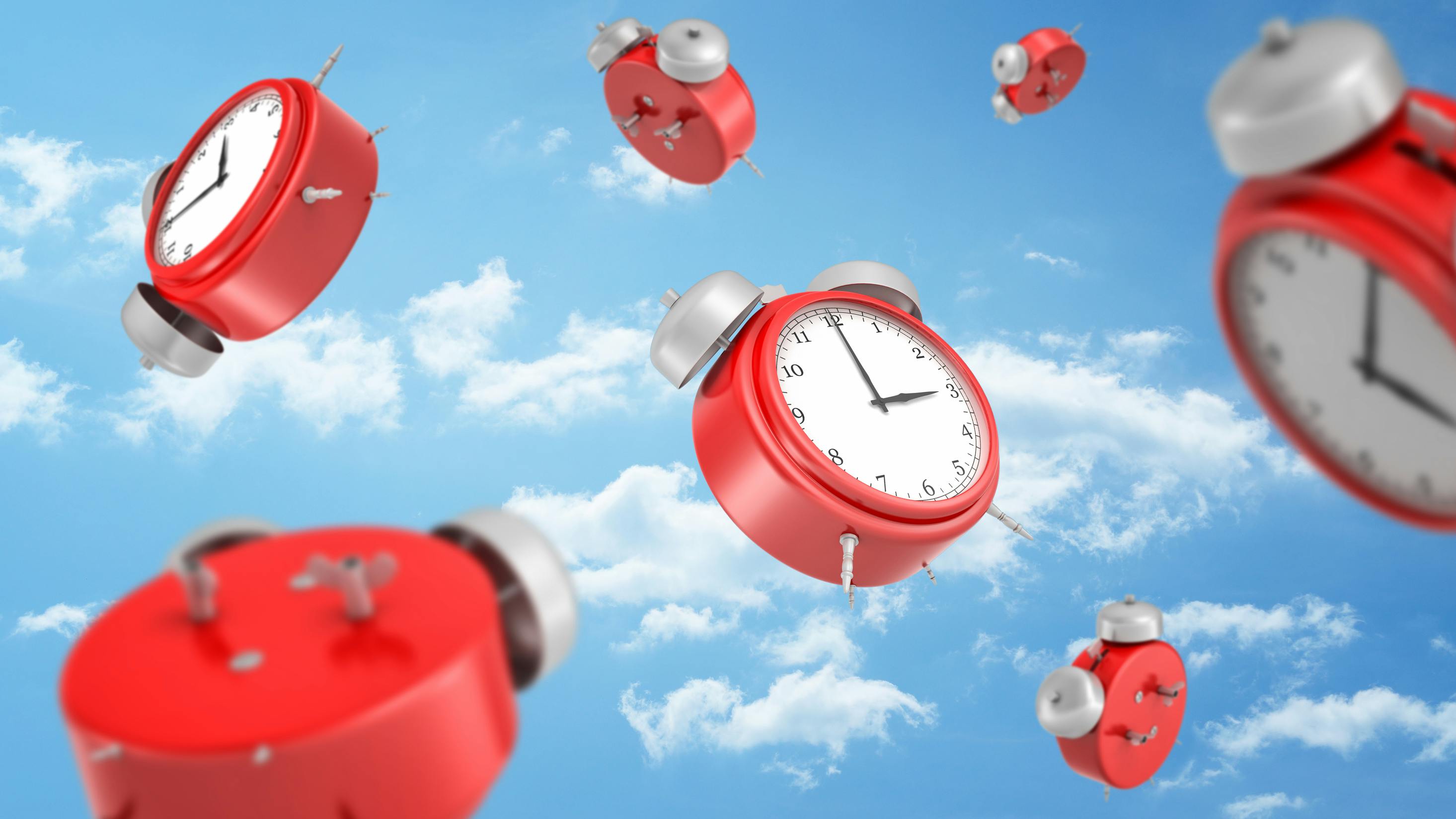 Red alarms clocks in a blue sky