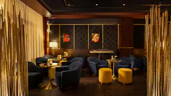 Dim, moody lounge area with soft seating and bamboo paneling.