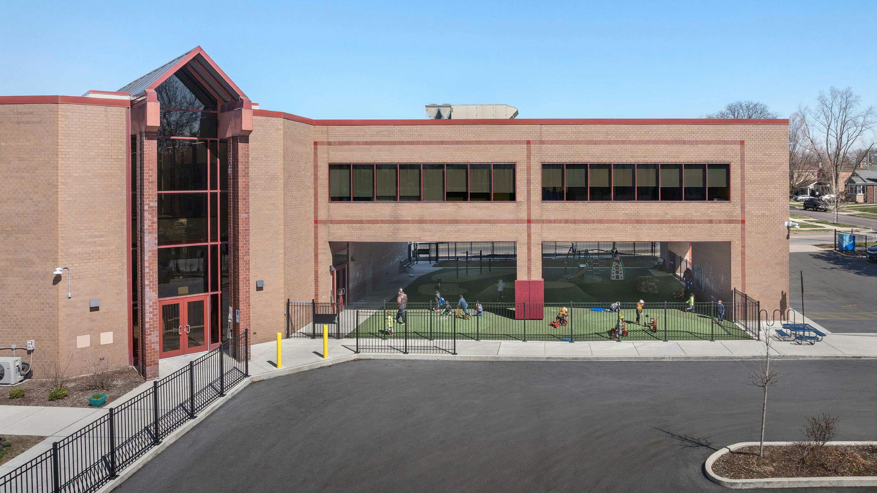 Exterior angled view of Barbara Vick Western Branch school, a multi-story early education center with an outdoor fenced play yard
