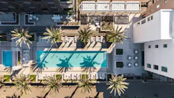 Aerial view of planned multiresidential community with pool and outdoor leisure spaces
