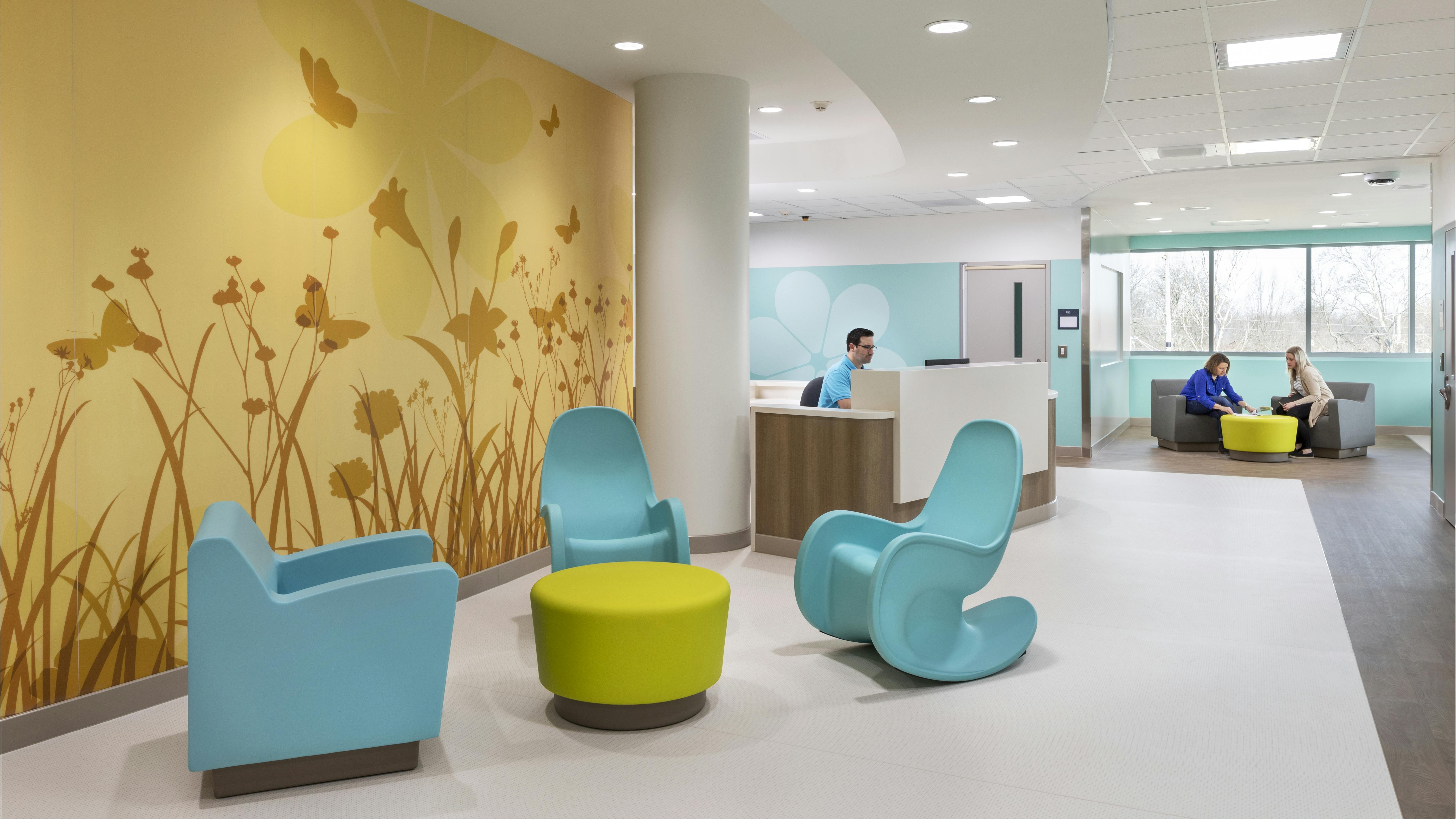 Visitor area in pediatric neuro behavioral healthcare unit with soft seating and silhouetted meadow wall mural