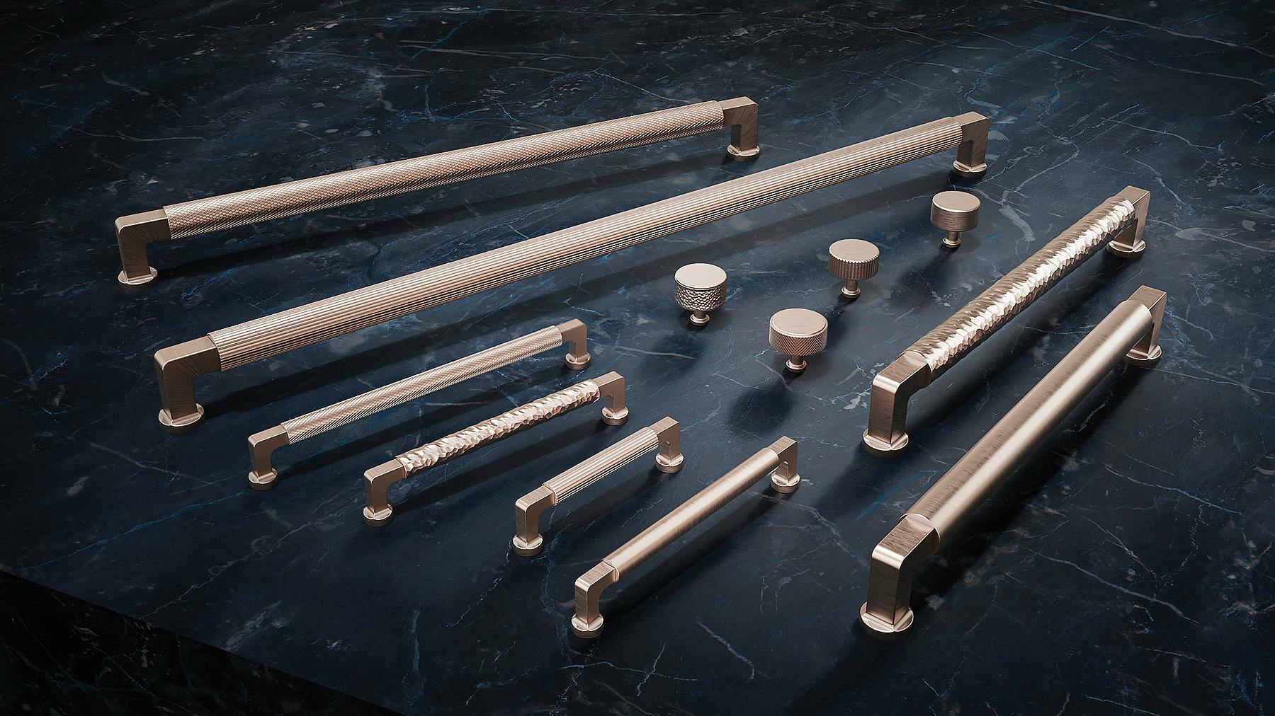 Elsinore decorative hardware collection, featuring rounded top inserts, hammered, knurled, pinstriped, and smooth pulls set on a counter, from California Faucets.