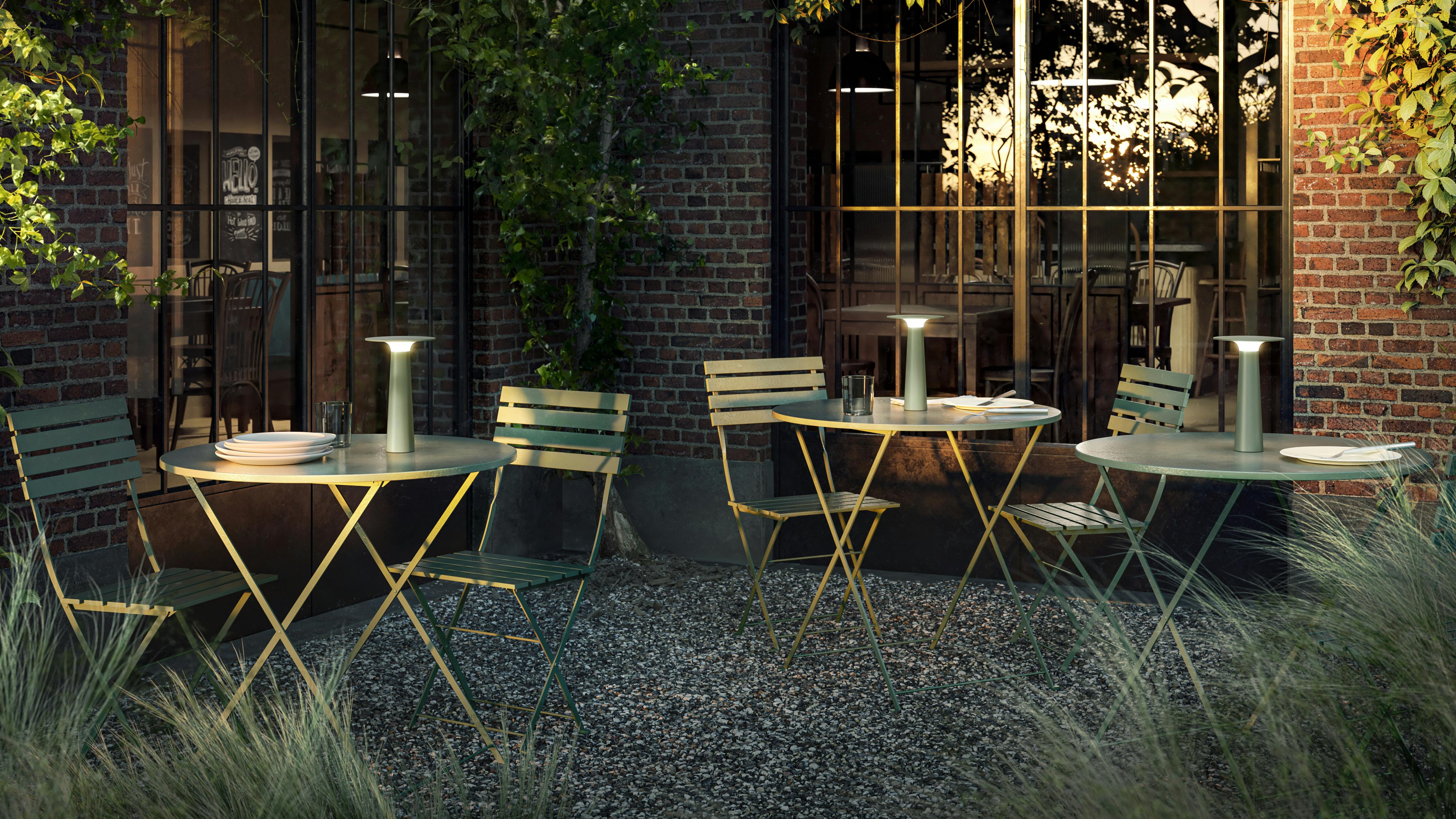 The Lix Portable Outdoor Table Lamp features glare-free illumination and intuitive touch dimming. The portable outdoor table lamps are set on patio tables.