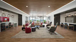 A large social space with layered lighting, daylight access, and multiple seating arrangements from a central lounge setup to counters with task chairs and individual soft seating.