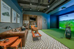 Golf simulator room with deep, soft sofa and armchair and coffee tables