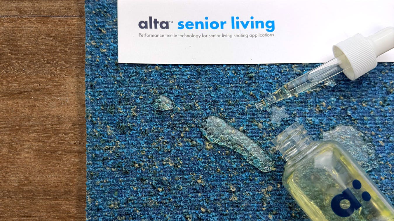 Alta Senior Living upholstery fabric with a bottle and pipette spilt on top.