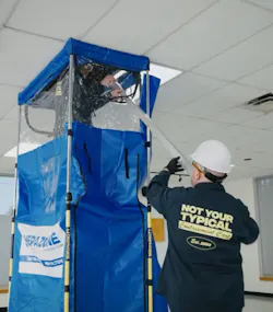 Contract worker uses a portable dust containment system to perform ceiling work while maintaining clean conditions in the area