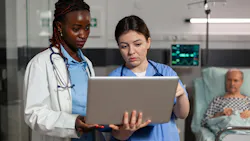 Black female doctor and white female nurse discussing care plan, with senior white male patient in the background