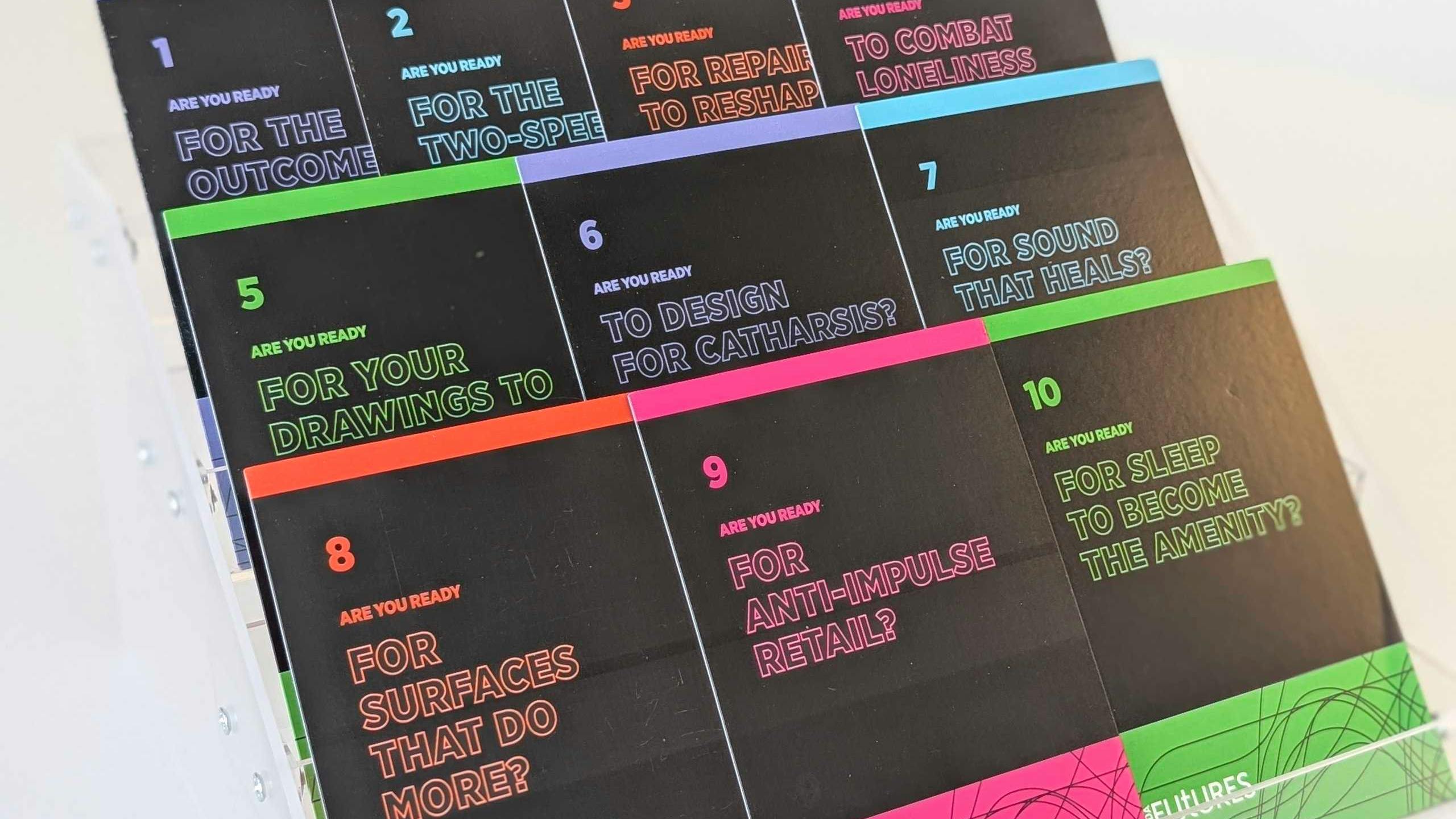 Ten colorful cards with thought-provoking questions about the future on acrylic display case.