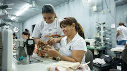 Two women work together to sew fabric into bags at New Hope Girls’ facility in the Dominican Republic.