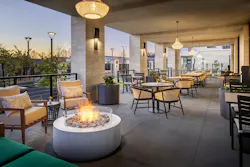 Rooftop terrace with canopy, fire pit, soft outdoor lighting, and various seating arrangements