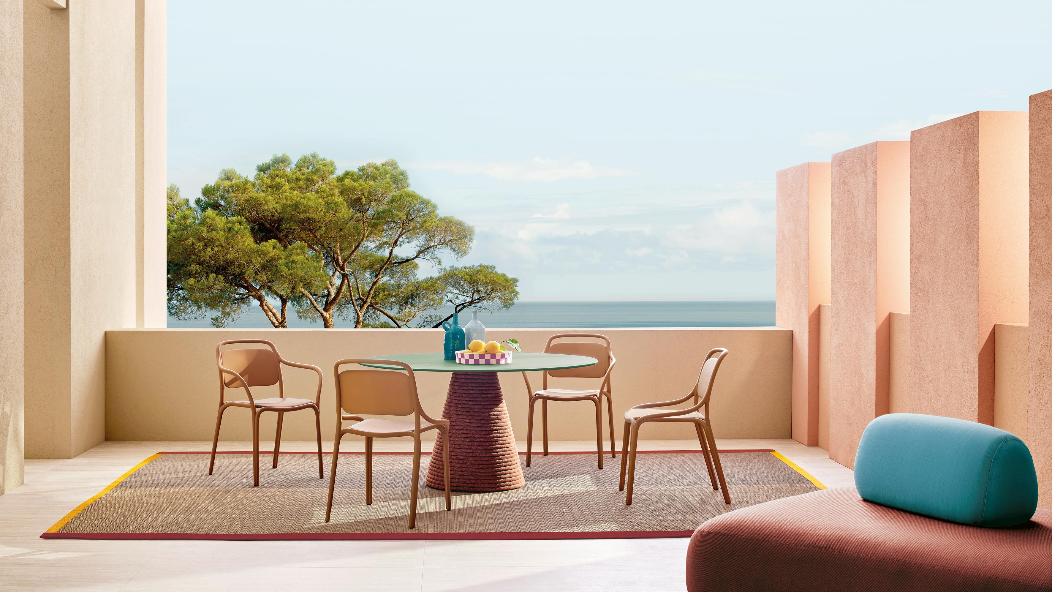 The Libre is a polypropylene, stackable armchair. It is shown in an outdoor setting around a table.