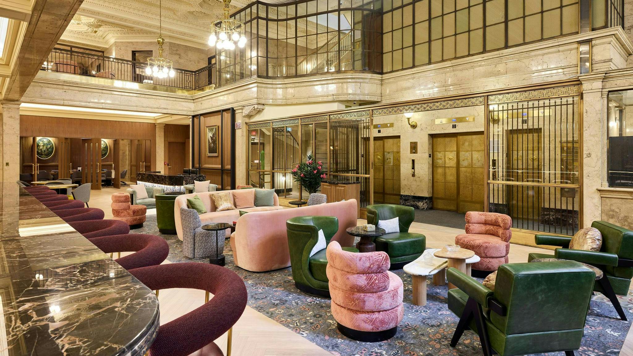 A mix of velvet, leather, and woven textile upholstered chairs in various seating areas throughout an Art Deco lobby