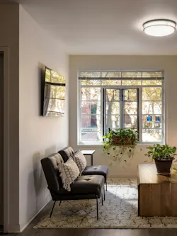 Side view of renovated apartment living room with large window view to the outdoor courtyard