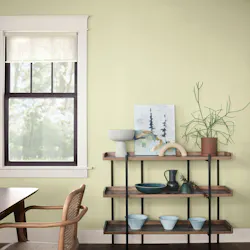 Casual dining room with pale yellow-green shade Celery on the walls, complemented by cool charcoal-brown and cream-colored trims and neutral wood furnishings