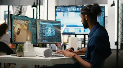 Designer in a corporate office using machine learning, cognitive computing and cybernetics to analyze blueprints and property layouts.