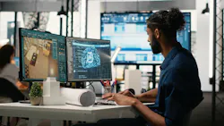 Designer in a corporate office using machine learning, cognitive computing and cybernetics to analyze blueprints and property layouts.