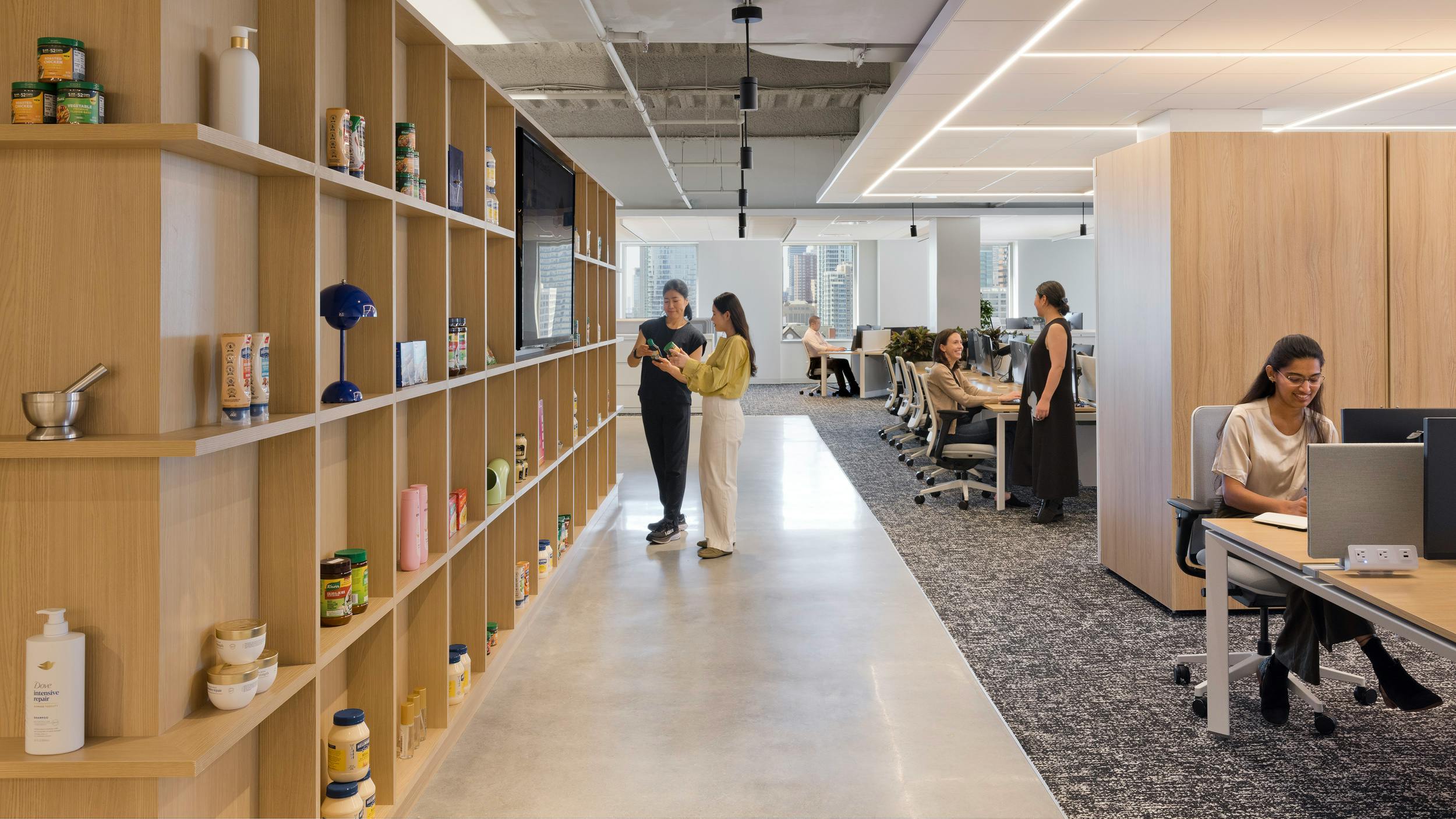 Flexible work zones at Unilever that showcase products in the foreground and adjoining workspaces, one with an open floorplan and a divider to the next work zone