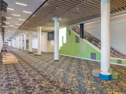 Convention center escalator with green wall to correspond with adjacent hall