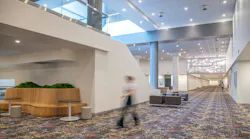 A long interior view of convention center shows updated lighting, carpet, and informal seating zones