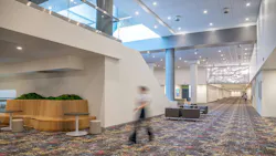 A long interior view of convention center shows updated lighting, carpet, and informal seating zones