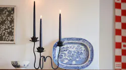 A closeup of the candelabra with three black candles lit on top.