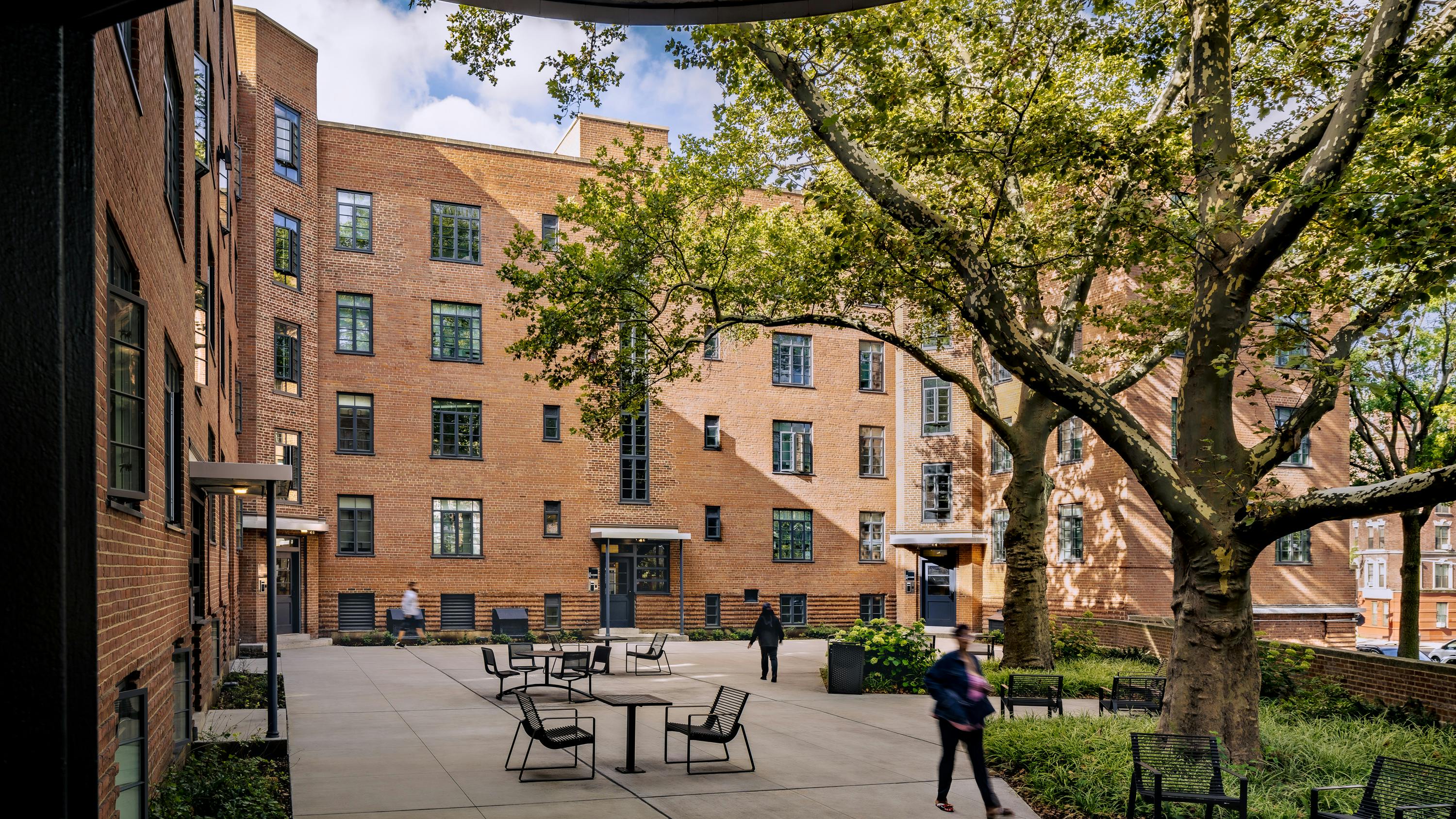 Revitalized open-air gathering spaces honor the Modernist planning legacy. Removal of non-historic fencing restores connection to the landscape.