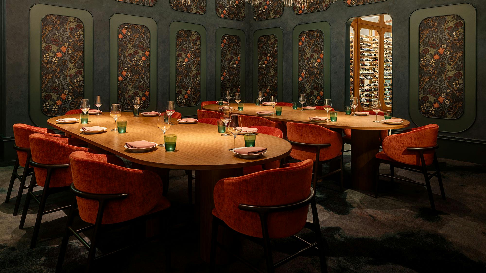 Deep jewel tones, botanical print wallcoverings, and velvet upholstery lend cozy, intimate ambiance to contemporary dining space