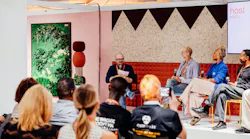 Tanner Woodford, founder of Iterative Work, moderates a panel discussion of four guests on stage at NeoCon 2026, in Chicago. Audience members sit in chairs and listen to the discussion. The 2027 NeoCon Call for Programming opened in October 2026.